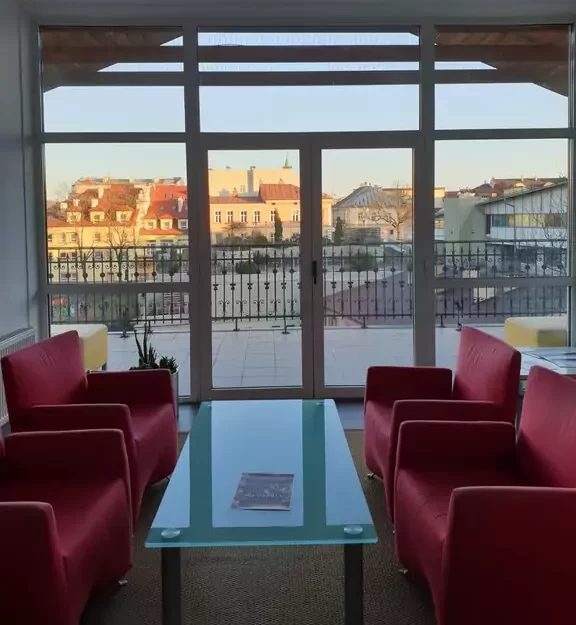 wynajem lokali w centrum sanoka. obraz przedstawiający wnętrze kamienicy na poddaszu, w tle centrum Sanoka