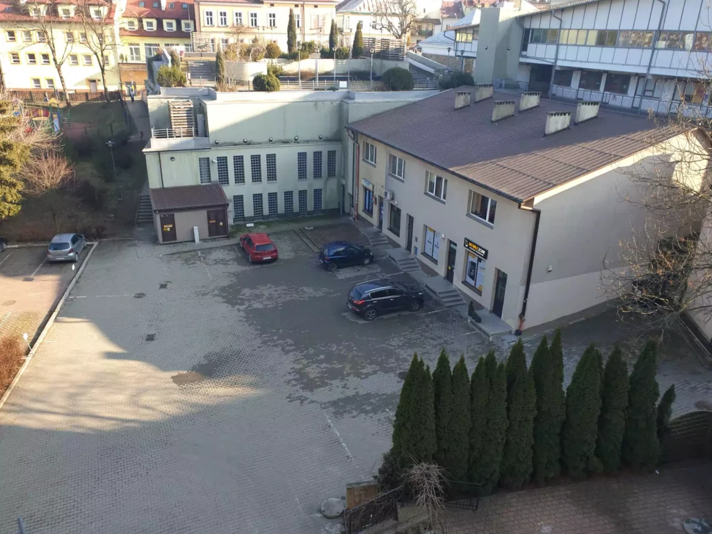 Parking w Sanoku - junosza smart parking. Okazujący parking znajdujący się za kamienicą